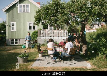 Multi-generation family having lunch at patio during garden party Stock Photo