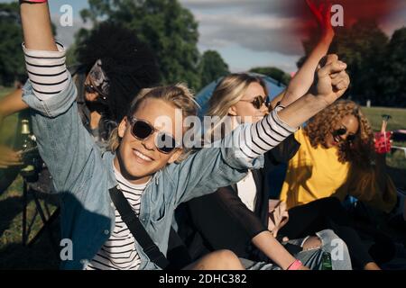 Happy young man enjoying with friends in music festival Stock Photo