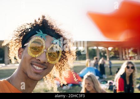 Close-up portrait of smiling man wearing novelty glasses at music concert Stock Photo