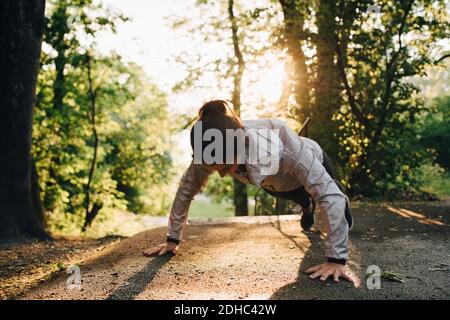 Young female athlete doing push-ups in park Stock Photo