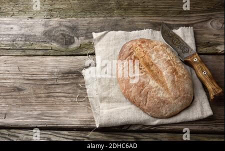 Oval baked rye flour bread on gray linen napkin Stock Photo