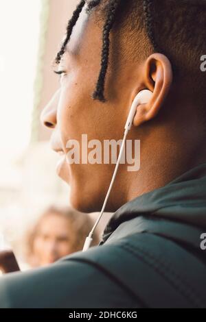 Teenage boy listening music on headphones in city Stock Photo