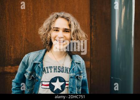 Portrait of smiling young man wearing denim jacket in city Stock Photo