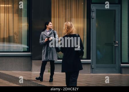 Businesswomen walking against building in city Stock Photo