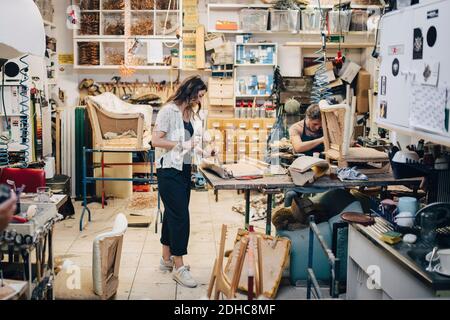 Male and female upholstery workers working in workshop Stock Photo