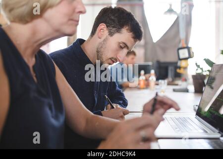 Male and female computer programmers working at desk in creative office Stock Photo