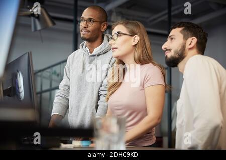 Creative business people watching presentation at desk in office Stock Photo