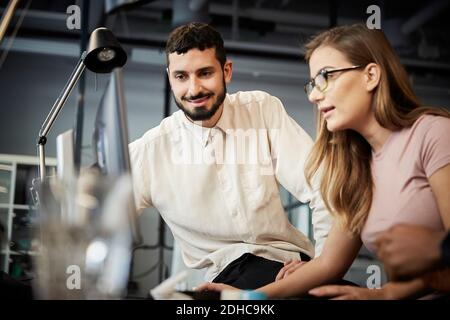 Male and female entrepreneurs looking at computer during meeting in office Stock Photo