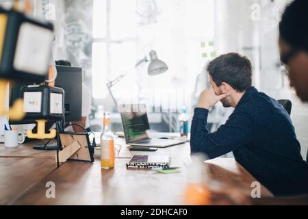 Male computer programmer working at desk in creative office Stock Photo