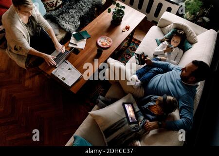 High angle view of family using various technologies in living room at home Stock Photo