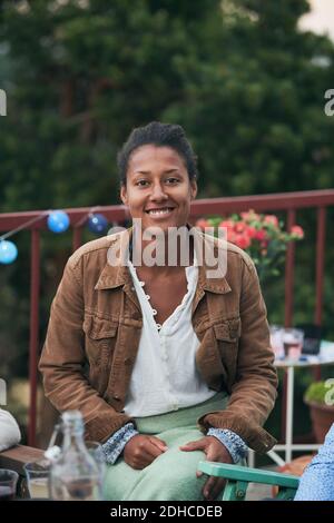 Portrait of smiling confident woman partying on terrace Stock Photo