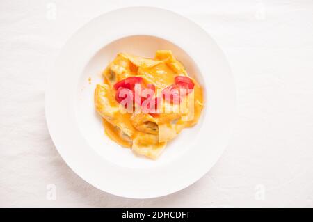 delicious stuffed mezzaluna pasta made from scratch with heirloom tomato sauce Stock Photo