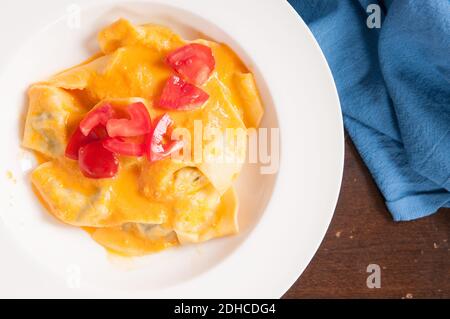 delicious stuffed mezzaluna pasta made from scratch with heirloom tomato sauce Stock Photo