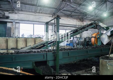 Rubber recycling processing factory, industrial equipment and conveyor line with cut used car tires. Recycling waste. Stock Photo