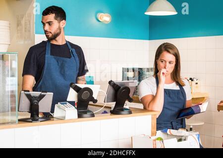 Young multi-ethnic colleagues at checkout in restaurant Stock Photo