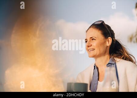Close-up of thoughtful woman having coffee against sky Stock Photo