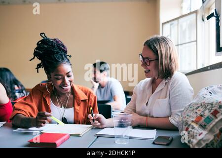 Happy female students studying together in language school Stock Photo