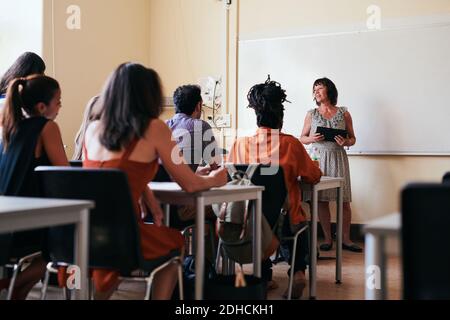 Teacher explaining to students in classroom Stock Photo