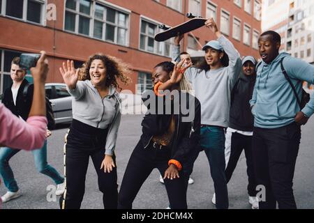 Happy multi-ethnic friends dancing on road in city Stock Photo