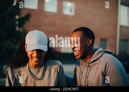 Young friends laughing while talking in city Stock Photo