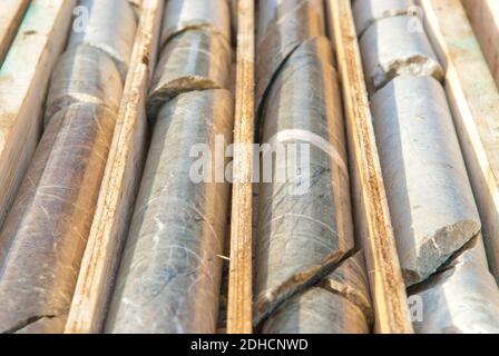 A closeup of the stacked drilled core samples from mines in wooden boxes Stock Photo