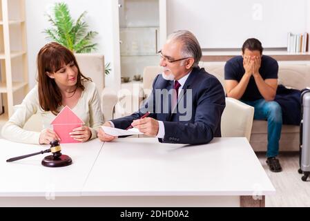 Old experienced judge and young couple in divorcing concept Stock Photo