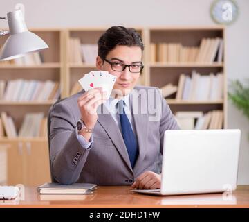 Businessman gambling playing cards at work Stock Photo