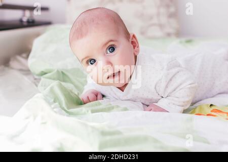 adorable baby boy with big eyes and long eyelashes. cute baby lying on his stomach Stock Photo