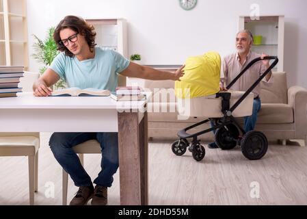 Retired grandfather looking after newborn at home Stock Photo