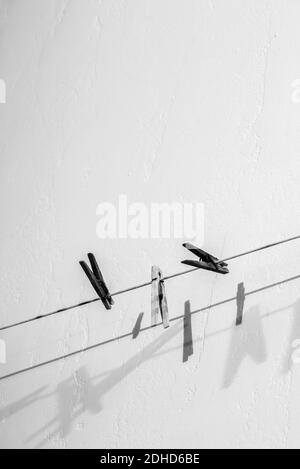 Three clothespins hanging on a line. Stock Photo