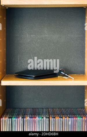 A wallet and keys lying on a wooden media tower. Stock Photo