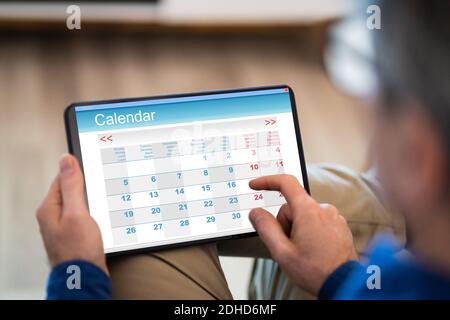 Man Using Calendar Agenda On Tablet Computer Stock Photo