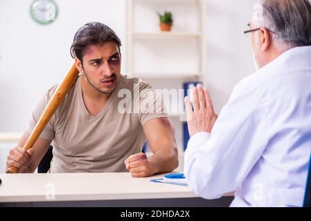 Young face injured man visiting experienced male doctor traumato Stock Photo