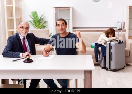 Old experienced judge and young couple in divorcing concept Stock Photo