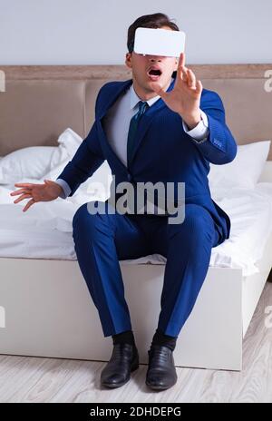 Businessman wearing a virtual reality headset in the bedroom Stock Photo