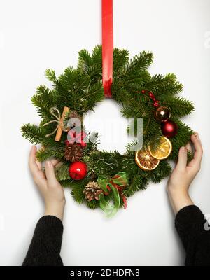 Beautiful Christmas wreath in woman hands. Festive interior decor. Stock Photo