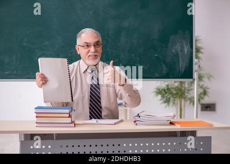 Old male teacher in the classroom Stock Photo