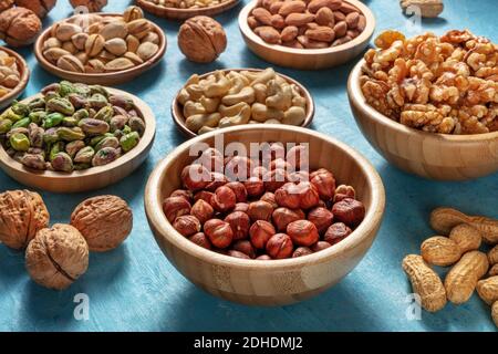 Many different nuts in wooden bowls Stock Photo