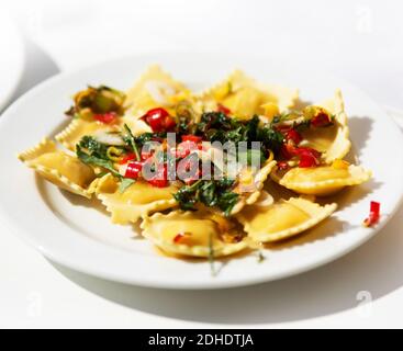 Ravioli garnished with basil leaves on white plate Stock Photo
