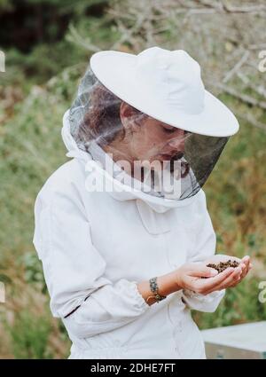 A portrait of a woman beekeeper with dead bees in the hands Stock Photo