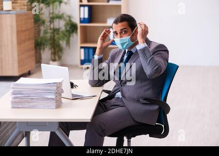 Young male employee wearing mask during pandemic Stock Photo