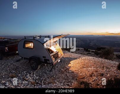 teardrop RV camper at campsite at twighlight with lights on, Utah Stock Photo