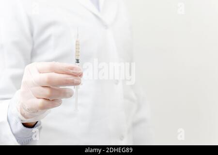 Doctor holding syringe with vaccine before immunization and vaccination on white background. Medical Trial. White background with copyspace. Stock Photo