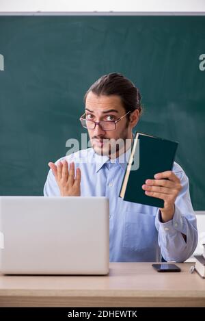 Young male teacher in the classroom in tele-education concept Stock Photo