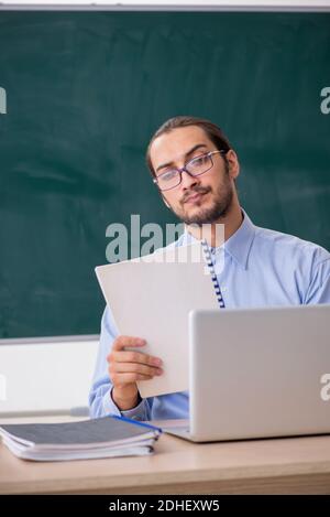 Young male teacher in the classroom in tele-education concept Stock Photo