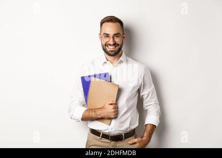 Young handsome man holding notebooks, concept of e-learning and courses Stock Photo