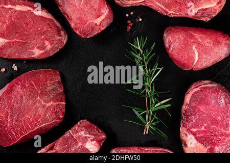 Meat, many different cuts, forming a frame on a dark slate background Stock Photo