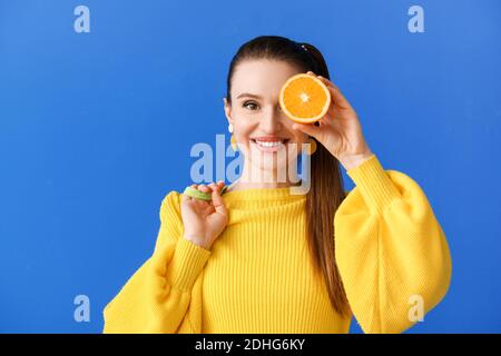 Beautiful young woman with orange on color background Stock Photo