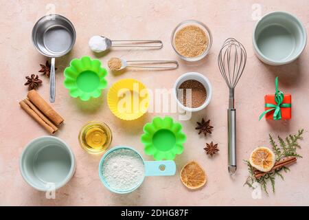 Ingredients for Christmas muffins and baking utensils on color background Stock Photo