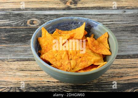Taco flavored corn tortilla chips in ceramic snack bowl in table Stock Photo